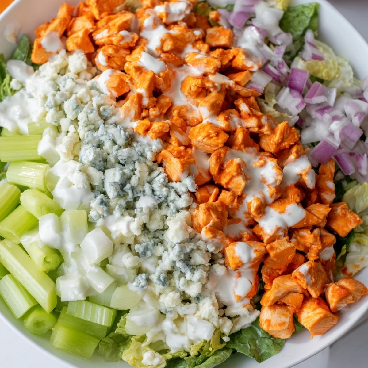 Hearty Buffalo Chicken Chopped Salad served in a rustic bowl, featuring juicy chicken, crisp veggies, and a drizzle of bold dressing.
