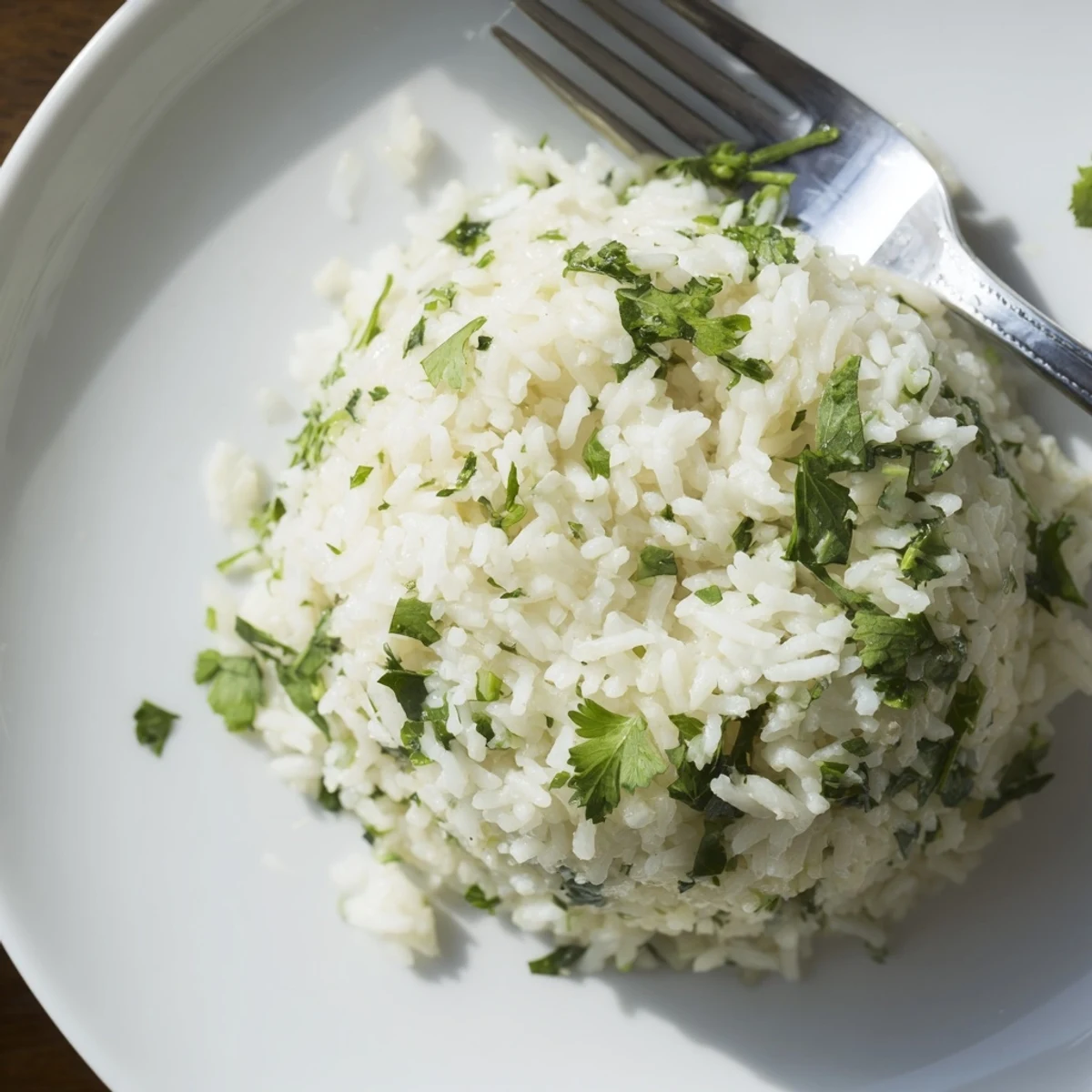 Fluffy Cilantro Lime Rice served warm, garnished with fresh chopped cilantro and a lime wedge on a rustic plate.