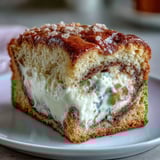 Freshly baked Cream Cheese Cinnamon Swirl Banana Bread with a moist crumb and sweet glaze, ready for breakfast or dessert.