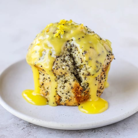 Fluffy lemon poppy seed muffins, golden brown and glazed, perfect for a cozy morning treat.