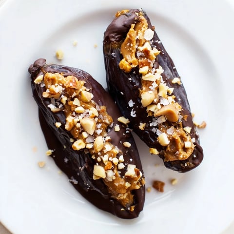 Chocolate Date Snickers coated in dark glossy chocolate, enticing view of the homemade candy.