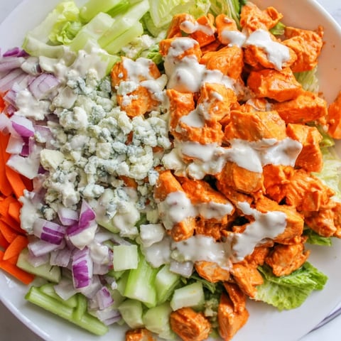 A vibrant Buffalo Chicken Chopped Salad with spicy chicken, crisp romaine, celery, and creamy blue cheese drizzled with ranch dressing.