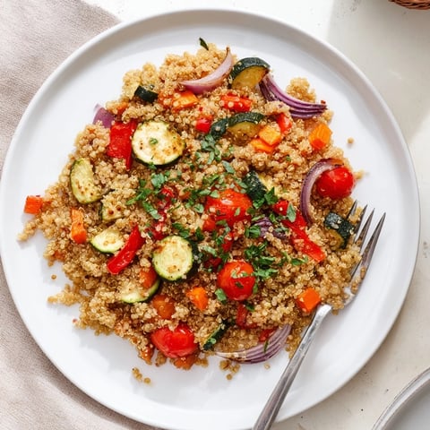 Fork-fluffed quinoa vegetable pilaf with golden roasted vegetables, fresh herbs, and a bright lemon finish.