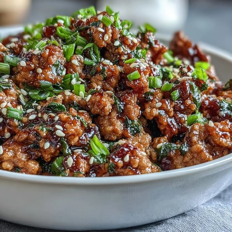 Korean-Style Ground Turkey cooked in a glossy, spicy-sweet sauce with garlic and ginger, served over steamed rice and topped with sesame seeds.
