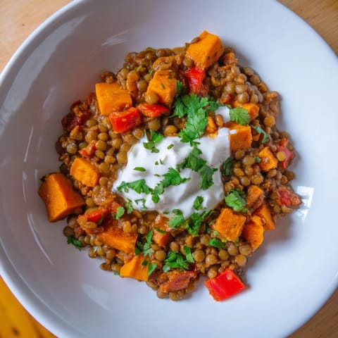A close-up shot of hearty Wheat-Warm Lentil Curry, a savory meal ready to be enjoyed with crusty bread.