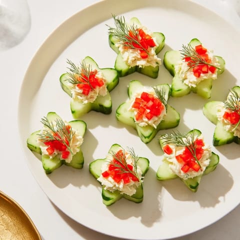 Freshly made Cucumber and Dill Christmas Stars appetizer, showcasing beautifully shaped cucumbers and a flavorful creamy filling.
