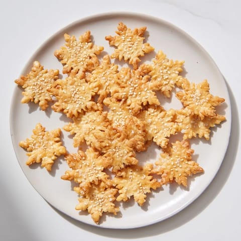 Golden baked Gourmet Crackers: snowflake cutouts for your holiday cheese board pleasure.