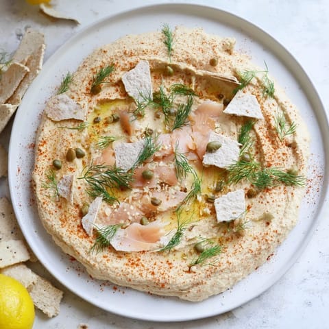 Appetizing "Driftwood Beach" with flaky smoked fish, vibrant garnishes, and hummus "shoreline".