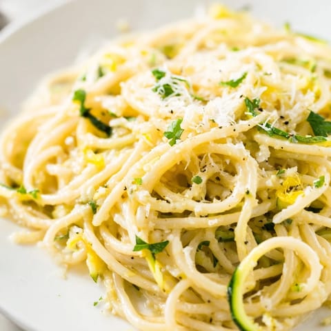 Spiralized zucchini noodles and al dente pasta are coated in a zesty, garlicky lemon butter sauce in this fresh, light main dish.