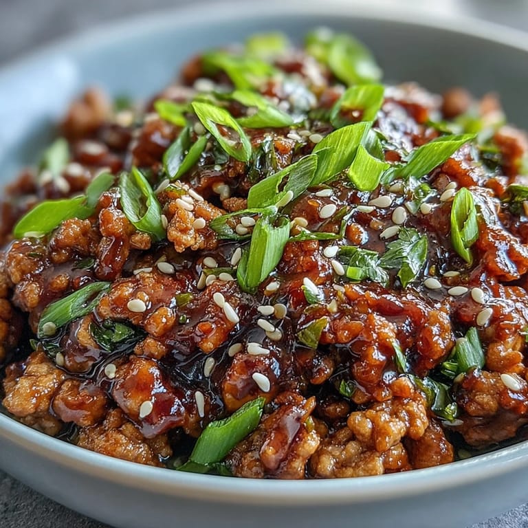Sizzling skillet of Korean-Style Ground Turkey with chopped chives and toasted sesame seeds, a quick, high-protein weeknight dinner inspiration.